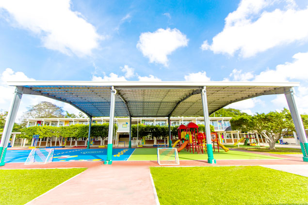 Estructura colegio, nubes de fondo con pasto verde